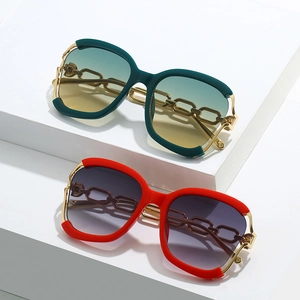 Lunettes de soleil oversize tendance avec monture à chaîne dorée sur blocs géométriques