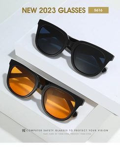 Detail showing oversized black and orange fashion sunglasses on a white display block
