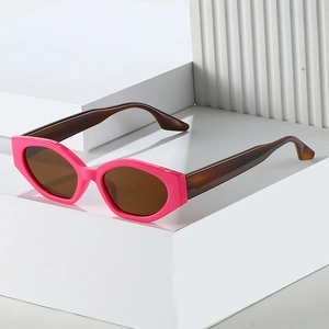Lunettes de soleil œil de chat à monture rose et verres bruns sur support blanc
