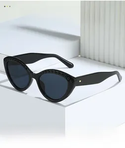 Detail of cat eye sunglasses with decorative beads and golden rivets on black frame