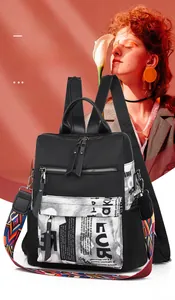 Close-up of waterproof Oxford fabric backpack with contrast newspaper print and woven strap