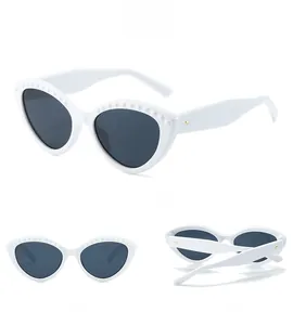 Detail views of white cat-eye sunglasses with pearl-like stud details and grey lenses