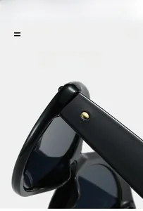 Detail of black cat-eye sunglasses with golden metal rivet and high-gloss texture