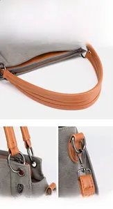 Detail of thickened brown leather handle and metal hardware on a grey canvas tote bag
