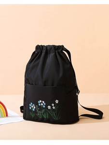 Detail of floral embroidery on a black waterproof nylon drawstring backpack bag