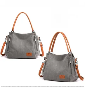 Detail of gray canvas tote with brown leather handles and classic fashion emblem