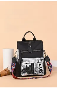 Close-up of black nylon backpack featuring graffiti print front pocket and ethnic woven strap