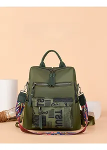 Macro shot of dark green Oxford backpack featuring vibrant ethnic style woven shoulder straps