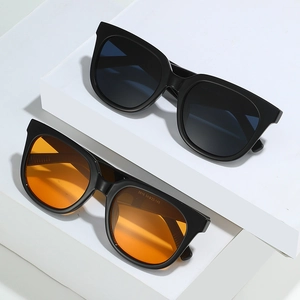Women's oversized square sunglasses with black frames and colorful lenses set on white blocks