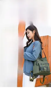 Detail of detachable colorful knitted shoulder strap and metal hook on olive green backpack