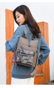 Detail of woman wearing a stylish khaki oxford backpack with colorful ethnic strap