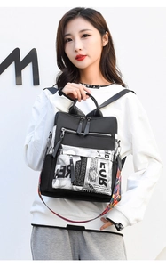 Detail of black oxford backpack with graphic print pocket and woven colorful strap