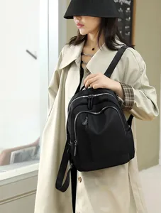 Detail of a waterproof black Oxford fabric backpack with multi-layer zipper pockets for travel