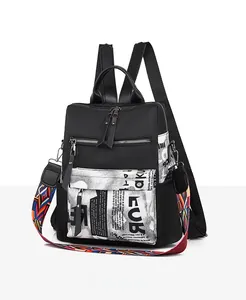 Detail of black oxford backpack with graffiti print and colorful woven shoulder strap