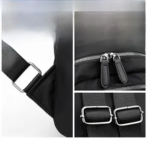 Detail view of silver metal zipper and D-ring buckle on black Oxford fabric backpack
