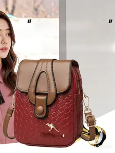 Detail of red woven texture and brown leather shoulder bag with golden logo