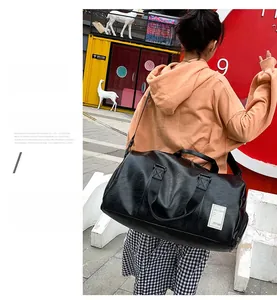 Close-up of black PU leather travel bag showing side zipper pocket and shoulder strap