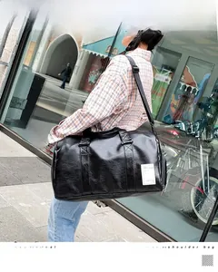 Detail of black faux leather travel bag with lychee texture and adjustable shoulder strap