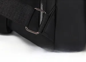 Detail of reinforced triangle stitching and metal D-ring on black oxford backpack