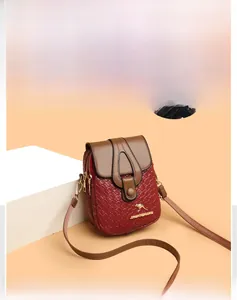 Detailed view of burgundy woven texture handbag with golden kangaroo logo and double zippers
