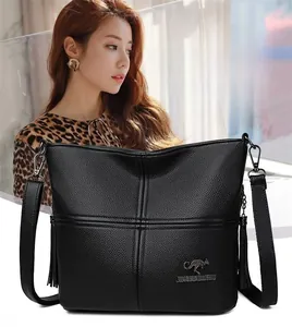 Close-up of black litchi pattern PU leather crossbody bag with tassel and kangaroo logo