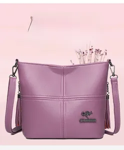 Detail view of purple textured leather bag with fringe tassels and kangaroo metal logo