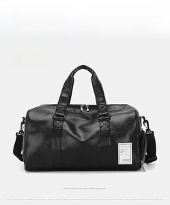 Close-up of black leather travel bag showing lychee grain texture and reinforced handles