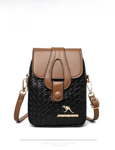 Detail of crossbody bag featuring gold kangaroo logo and brown contrast flap closure