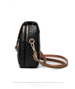 Detail of black woven leather texture and gold double zipper on a fashion crossbody bag
