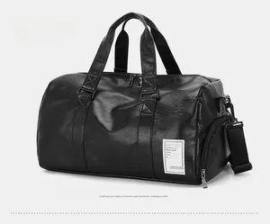 Detail of a black leather travel bag showing sturdy handles and a side shoe compartment