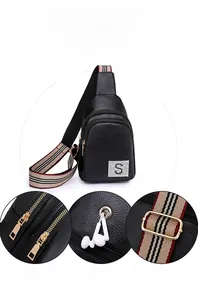 Detail view of PU leather sling bag with rhinestone S logo and striped shoulder strap