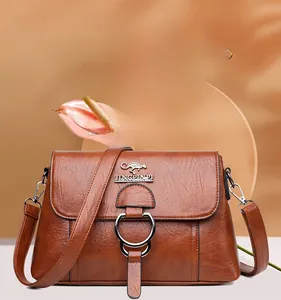 Detail of brown PU leather shoulder bag with circular metal ring and kangaroo metal logo