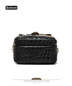 Detail view of woven leather texture on the bottom of the black crossbody bag
