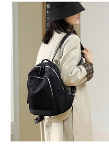 Lifestyle view of the black waterproof nylon backpack on a model with beige coat