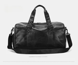 Detail view of the back of a large capacity black travel duffel bag with shoulder strap