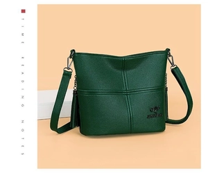 Close-up of deep green pebbled leather texture and kangaroo logo on the shoulder bag