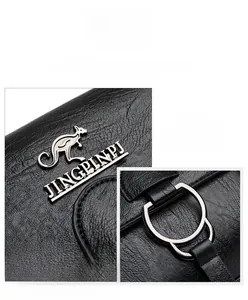 Detail of black litchi grain PU leather texture and silver kangaroo logo on handbag