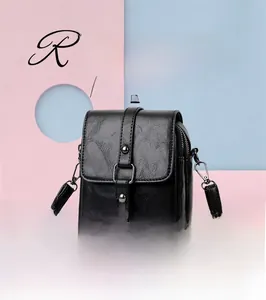 Detail of black faux leather texture and metal buckle on this stylish crossbody bag