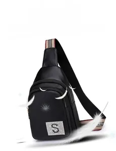 Detail of black pebbled leather chest bag with crystal S logo and striped shoulder strap