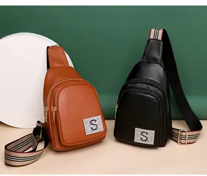 Detail of PU leather chest bags with S logo, gold zippers and striped adjustable straps
