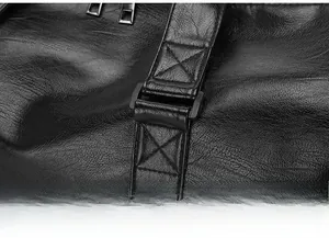 Detail of double-stitched reinforcement on black leather travel bag shoulder strap