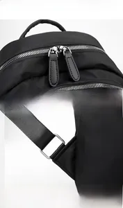 Close-up of waterproof Oxford fabric texture and silver metal double zippers on black backpack