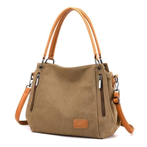 Women's khaki canvas tote bag with multi-zipper pockets and leather handles