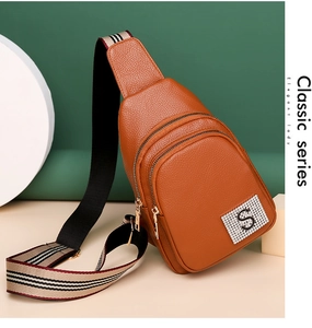 Detail of lychee pattern PU leather chest bag with striped strap and rhinestone S logo