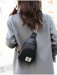 Detail of black pebbled PU leather chest bag with striped strap and mesh S logo patch