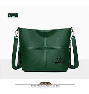 Close-up of green pebbled leather shoulder bag with kangaroo logo and side tassels