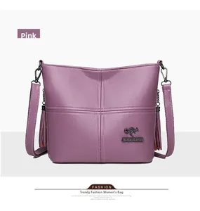 Close-up of pink litchi grain PU leather handbag with gold kangaroo logo and side tassels