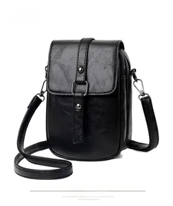 Detail of vintage black faux leather crossbody phone bag with silver rivets and metal ring
