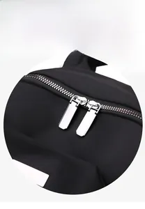 Détail de la double fermeture éclair en métal et du tissu oxford robuste du sac à dos