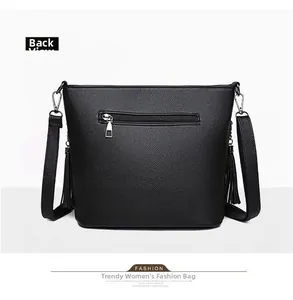 Detail view of the black pebbled leather bag back with a zipper pocket and tassels
